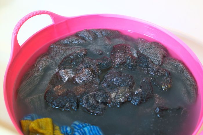 A tub full of soapy water and handknits