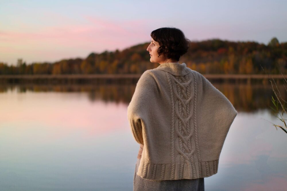 Kephren wearing the Augusta Cardigan at sunset on a river