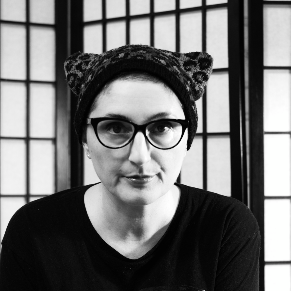 A black and white portrait of Kephren wearing a leopard spotted cat ear hat